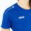 Ein blaues T-Shirt mit JAKO-Logo auf der Brust und Punkten auf der Schulter.