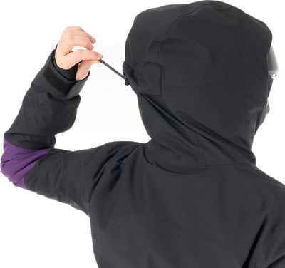 Eine Person passt die Kapuze einer Jacke mit einer Kordel an.