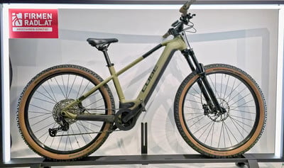 Grünes Cube E-Bike mit braunen Reifen auf einem Ständer.