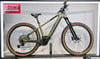 Grünes Cube E-Bike mit braunen Reifen auf einem Ständer.