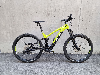 Grünes E-Bike mit Federung steht vor einer Betonwand.