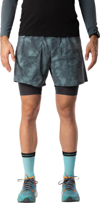 Ein Mann in grauer Laufshorts mit Innenbeinlingen und türkisfarbenen Socken. Ein Mann in grauer Laufshorts mit Innenbeinlingen und türkisfarbenen Socken.
