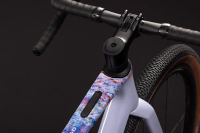 Detail eines Mountainbikes mit buntem Rahmen und schwarzem Lenker.