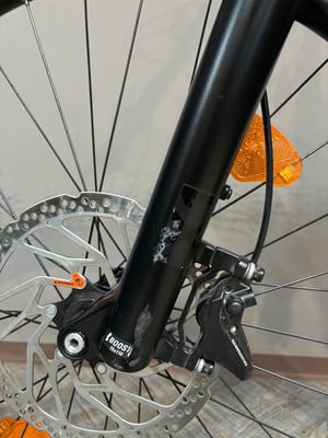 Fahrradgabel mit Bremsscheibe und orangem Reflektor. Fahrradgabel mit Bremsscheibe und orangem Reflektor.
