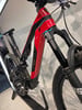 Ein rotes und schwarzes Mountain-Elektrofahrrad mit Federung.