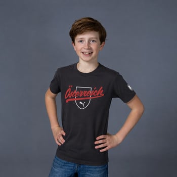 Ein Junge in einem dunklen T-Shirt mit der Aufschrift Österreich und dem Puma-Logo