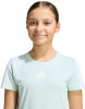 Mädchen in einem blaugrünen T-Shirt mit Adidas-Logo und Streifen an den Ärmeln.