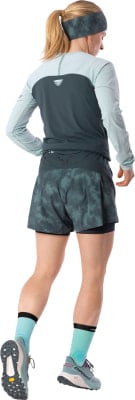 Eine Frau in Laufkleidung mit Stirnband, Langarmshirt und Shorts. Eine Frau in Laufkleidung mit Stirnband, Langarmshirt und Shorts.