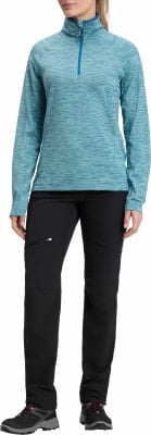 Frau in türkisfarbener Mikrofaserjacke und schwarzer Hose mit rosa Schnürsenkeln.