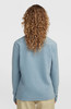 Damen-Pullover in Blau mit langen Ärmeln und lockigem braunem Haar.