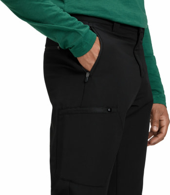 Ein Mann in einem grünen Hemd steckt die Hand in die Tasche einer schwarzen Hose. Ein Mann in einem grünen Hemd steckt die Hand in die Tasche einer schwarzen Hose.