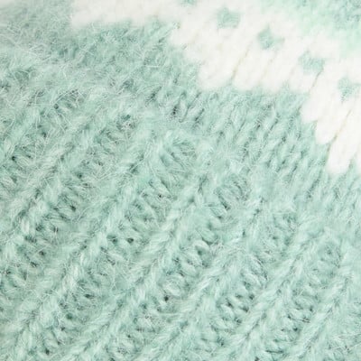 Detail eines Strickmusters mit weißem und hellgrünem Muster. Detail eines Strickmusters mit weißem und hellgrünem Muster.
