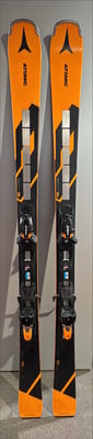 Atomic-Ski mit orange-schwarzem Design und schwarzen Bindungen.