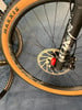 Detail eines Mountainbikes mit braunem Reifen und Scheibenbremse.