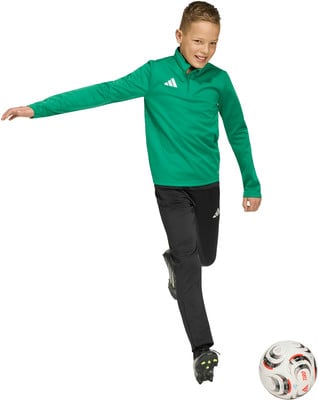 Junge in grünem Pullover und schwarzer Hose mit Fußball. Junge in grünem Pullover und schwarzer Hose mit Fußball.
