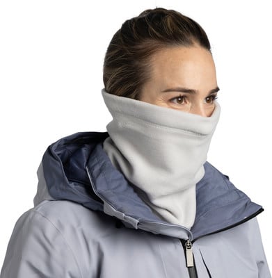 Eine Frau in einer grauen Jacke mit einem Schal um Hals und Gesicht. Eine Frau in einer grauen Jacke mit einem Schal um Hals und Gesicht.