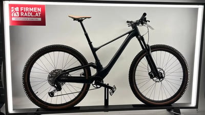Schwarzes Mountainbike mit braunem Sattel und braunen Reifen auf einem Ständer. Schwarzes Mountainbike mit braunem Sattel und braunen Reifen auf einem Ständer.