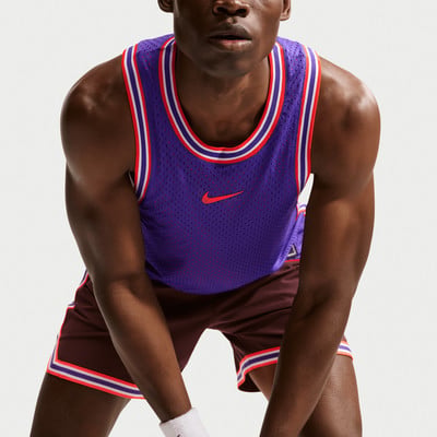 Mann in lila Nike Trikot und dunkler Hose mit Streifen.
