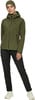 Eine Frau in einer grünen Jacke und schwarzen Hose mit einer Mütze.