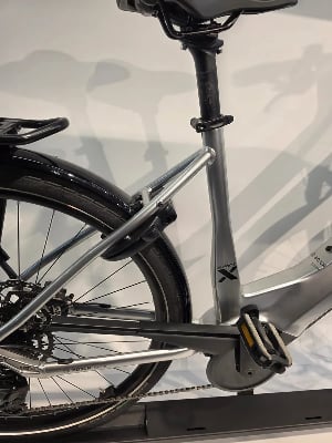 Rückseite eines silbernen E-Bikes mit Kette, Pedal und Schutzblech. Rückseite eines silbernen E-Bikes mit Kette, Pedal und Schutzblech.