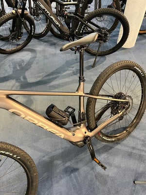 Ein Orbea Mountain-E-Bike mit Dämpfern und Federung auf blauem Teppich. Ein Orbea Mountain-E-Bike mit Dämpfern und Federung auf blauem Teppich.
