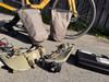 Zwei Fahrradtaschen hängen am Hinterrad, weiteres Zubehör liegt am Boden.