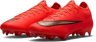 Vorderansicht eines Paares leuchtend roter Fußballschuhe mit einem bronzefarbenen Streifen. Vorderansicht eines Paares leuchtend roter Fußballschuhe mit einem bronzefarbenen Streifen.