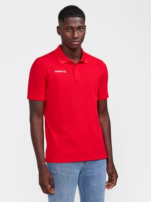 Ein Mann in einem roten Poloshirt und Jeans steht vor einem weißen Hintergrund. Ein Mann in einem roten Poloshirt und Jeans steht vor einem weißen Hintergrund.