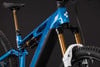 Ein blaues E-Mountainbike mit hochwertiger goldener Federgabel und Dämpfer.
