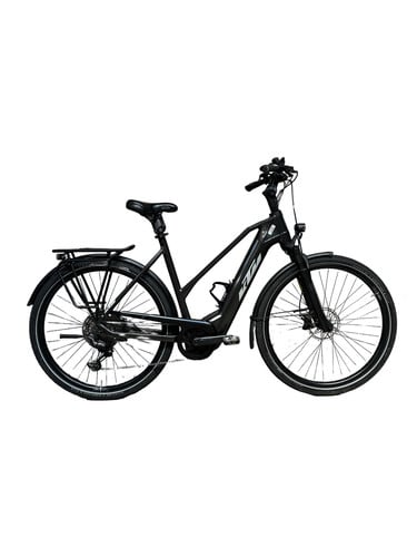 Schwarzes KTM E-Bike mit Gepäckträger und Schutzblechen vor weißem Hintergrund.