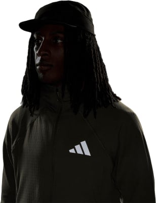 Ein Mann mit schwarzer Kappe und dunkler Jacke mit Adidas-Logo.