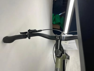 Detail einer Fahrradlenker mit Preisschild und Lichtreflexion.
