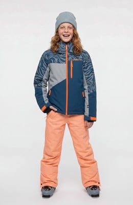 Junge in Skikleidung mit orangefarbener Hose und bedruckter Jacke Junge in Skikleidung mit orangefarbener Hose und bedruckter Jacke
