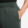 Detail einer dunkelgrünen Herren-Jogginghose mit Tasche und einer Hand darin.