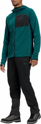 Mann in dunkelgrüner Fleecejacke mit Kapuze und schwarzer Hose Mann in dunkelgrüner Fleecejacke mit Kapuze und schwarzer Hose