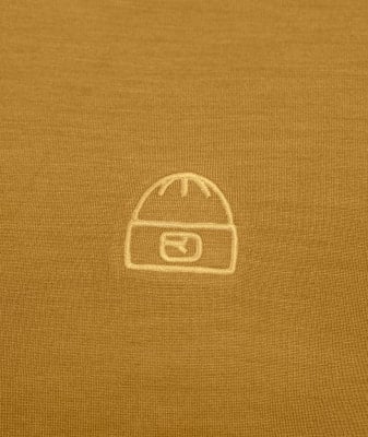 Auf einem gelben T-Shirt ist ein weißes Symbol einer Mütze mit einem Logo aufgestickt. Auf einem gelben T-Shirt ist ein weißes Symbol einer Mütze mit einem Logo aufgestickt.