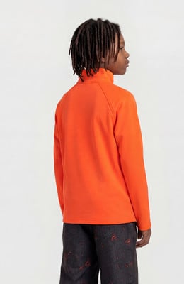 Junge mit Dreadlocks von hinten in orangefarbenem Sweatshirt und dunkler Hose. Junge mit Dreadlocks von hinten in orangefarbenem Sweatshirt und dunkler Hose.