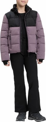 Mädchen in einer gesteppten Jacke und schwarzen Hose, bereit für den Winter.