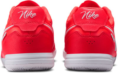 Pohľad zozadu na pár jasne červených tenisiek Nike s bielym logom. Pohľad zozadu na pár jasne červených tenisiek Nike s bielym logom.