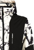 Jacke mit auffälligem schwarz-weißem Print und schwarzen Einsätzen an den Schultern.
