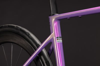 Lila Fahrradrahmen mit UCI-Logo und schwarzem Reifen. Lila Fahrradrahmen mit UCI-Logo und schwarzem Reifen.