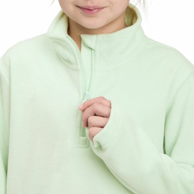 Ein Mädchen schließt einen hellgrünen Fleece-Pullover mit Reißverschluss am Kragen. Ein Mädchen schließt einen hellgrünen Fleece-Pullover mit Reißverschluss am Kragen.