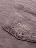 Detail eines Hemdes mit feinem Blumendruck und Logo.
