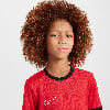 Ein Junge mit lockigem Haar trägt ein rotes T-Shirt mit Nike-Logo.