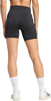 Eine Frau in schwarzen Shorts und weißen Socken mit Turnschuhen auf weißem Hintergrund. Eine Frau in schwarzen Shorts und weißen Socken mit Turnschuhen auf weißem Hintergrund.