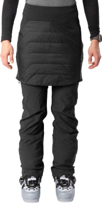 Frau in Skischuhen und Daunenschürze über Hose. Frau in Skischuhen und Daunenschürze über Hose.