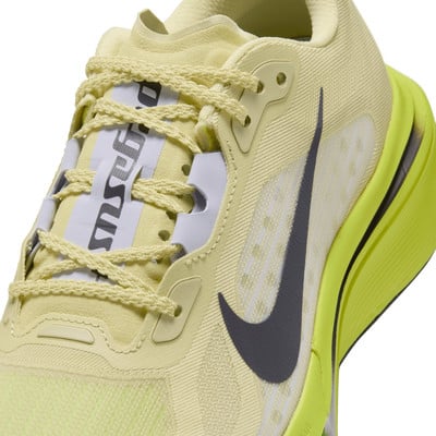 Nike futócipő részlete pasztellsárga felsőrésszel és sötétszürke logóval.