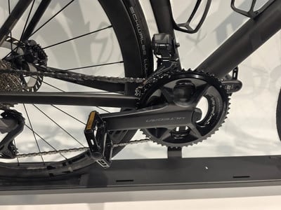 Detail des Kettenblatts und der Kette auf einem schwarzen Fahrrad mit weißem Hintergrund. Detail des Kettenblatts und der Kette auf einem schwarzen Fahrrad mit weißem Hintergrund.