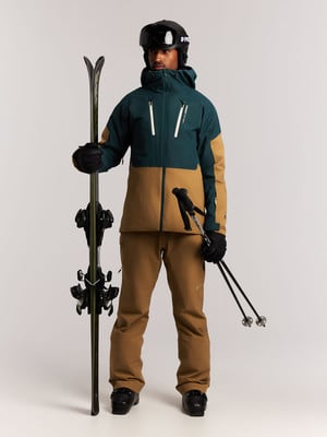 Ein Skifahrer hält Ski und Stöcke, gekleidet in Skibekleidung. Ein Skifahrer hält Ski und Stöcke, gekleidet in Skibekleidung.