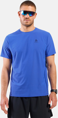Ein Mann in einem blauen T-Shirt und einer schwarzen Hose mit Brille.
